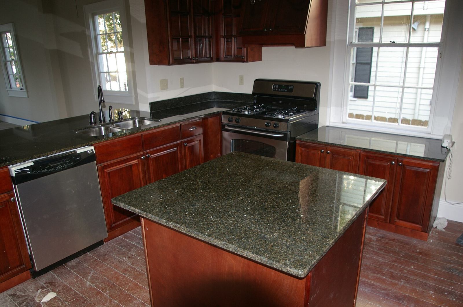 A compact kitchen with cabinets, a gas range, and a small island
